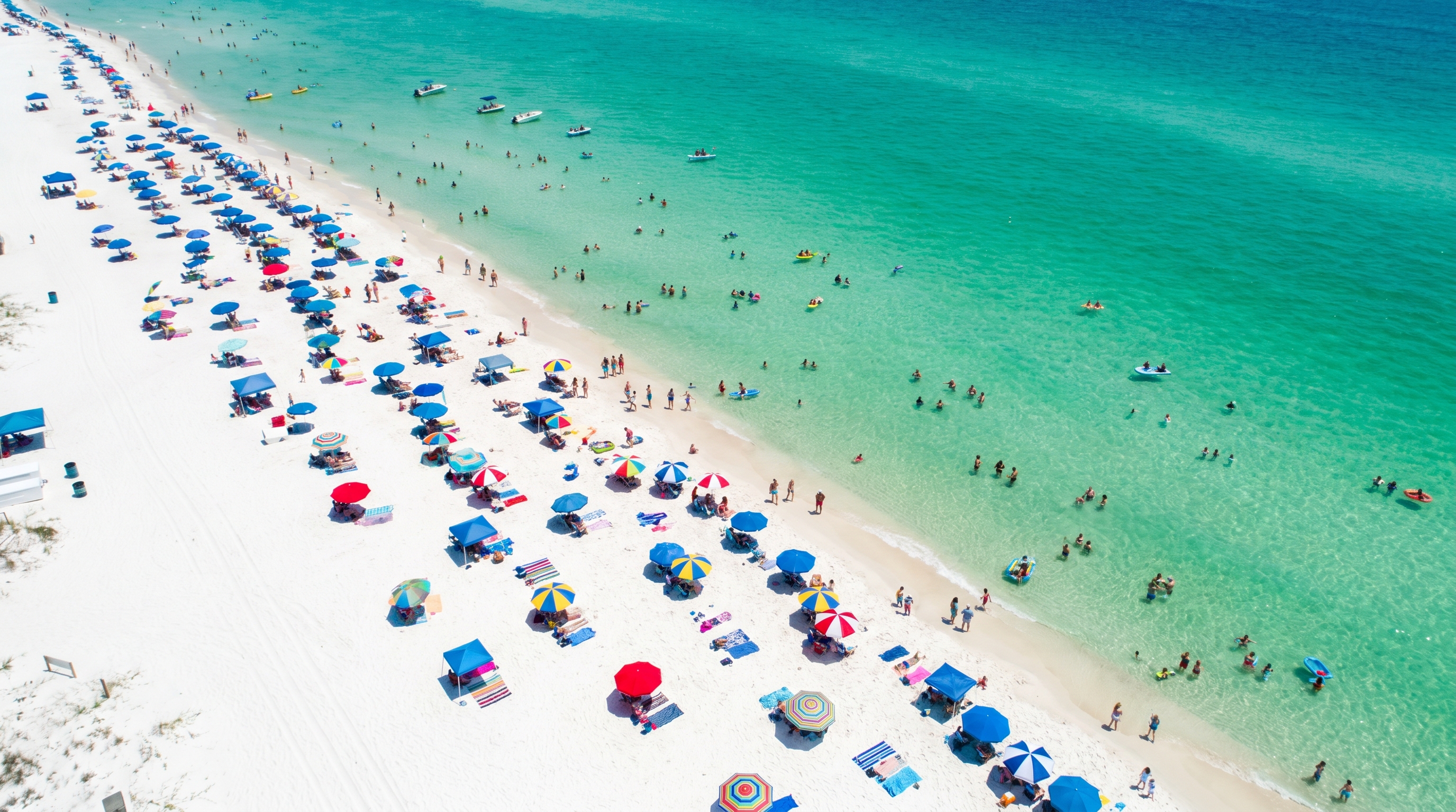 Families wading in shallow emerald-green water at Crystal Beach Destin Florida with colorful beach umbrellas on white sand
