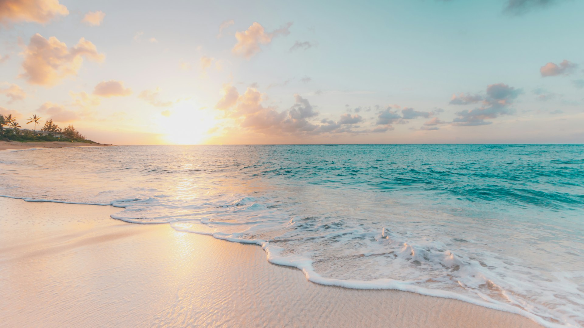 Peaceful sunrise over the emerald Gulf of Mexico in Destin Florida with calm water and empty white sand beach