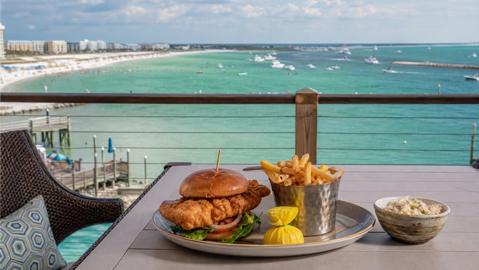 Beautifully plated grilled grouper fillet with herb butter, rice pilaf, and grilled asparagus at an upscale Destin Florida waterfront restaurant with Gulf view through window