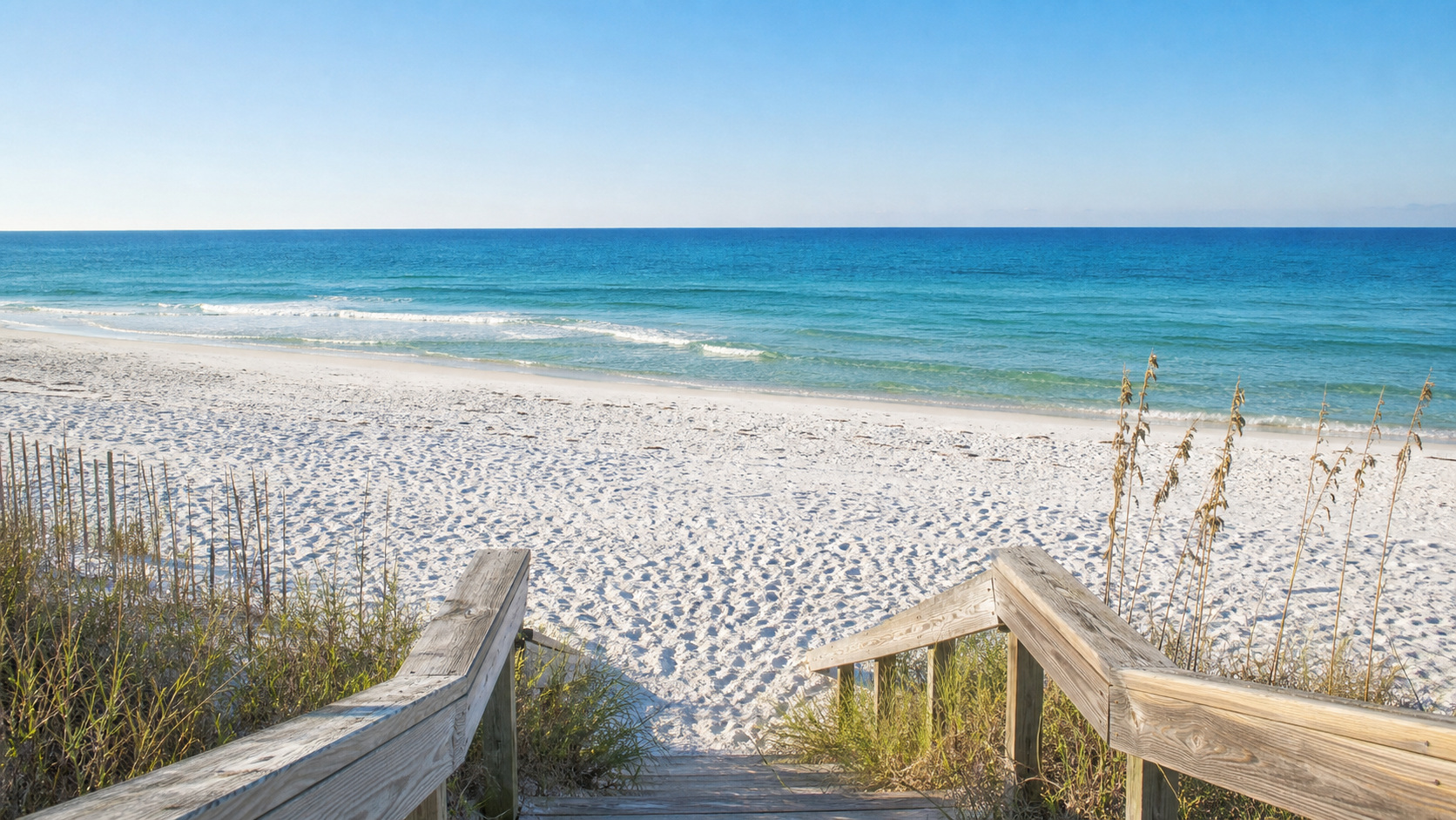 Secluded pristine white sand beach access point in Destin Florida with clear emerald green Gulf water and almost no people, morning light