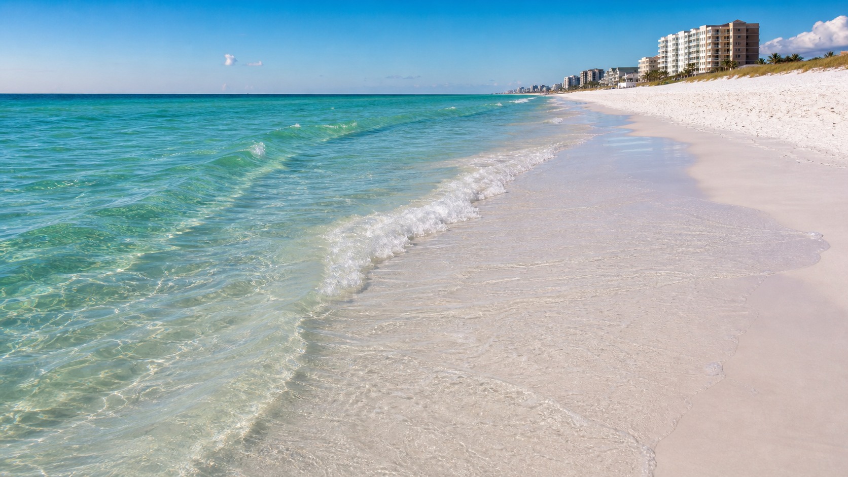 Crystal clear emerald green Gulf of Mexico water lapping white quartz sand beach in Destin Florida on a sunny summer day