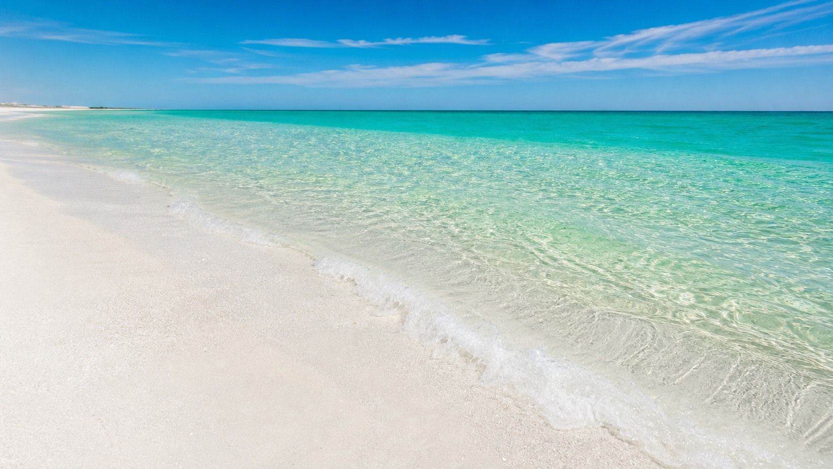 Brilliant white quartz sand and crystal-clear emerald green Gulf water at a Destin Florida beach