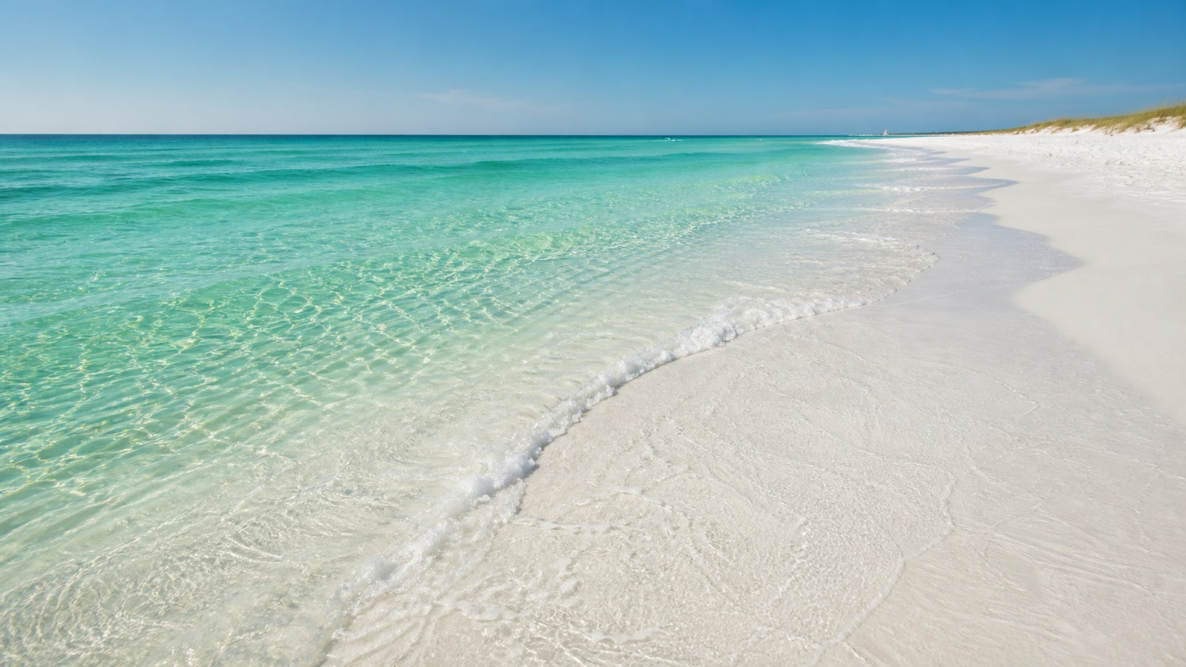 Crystal-clear emerald-green Gulf water lapping the brilliant white quartz sand at Destin Florida beach on a sunny summer day