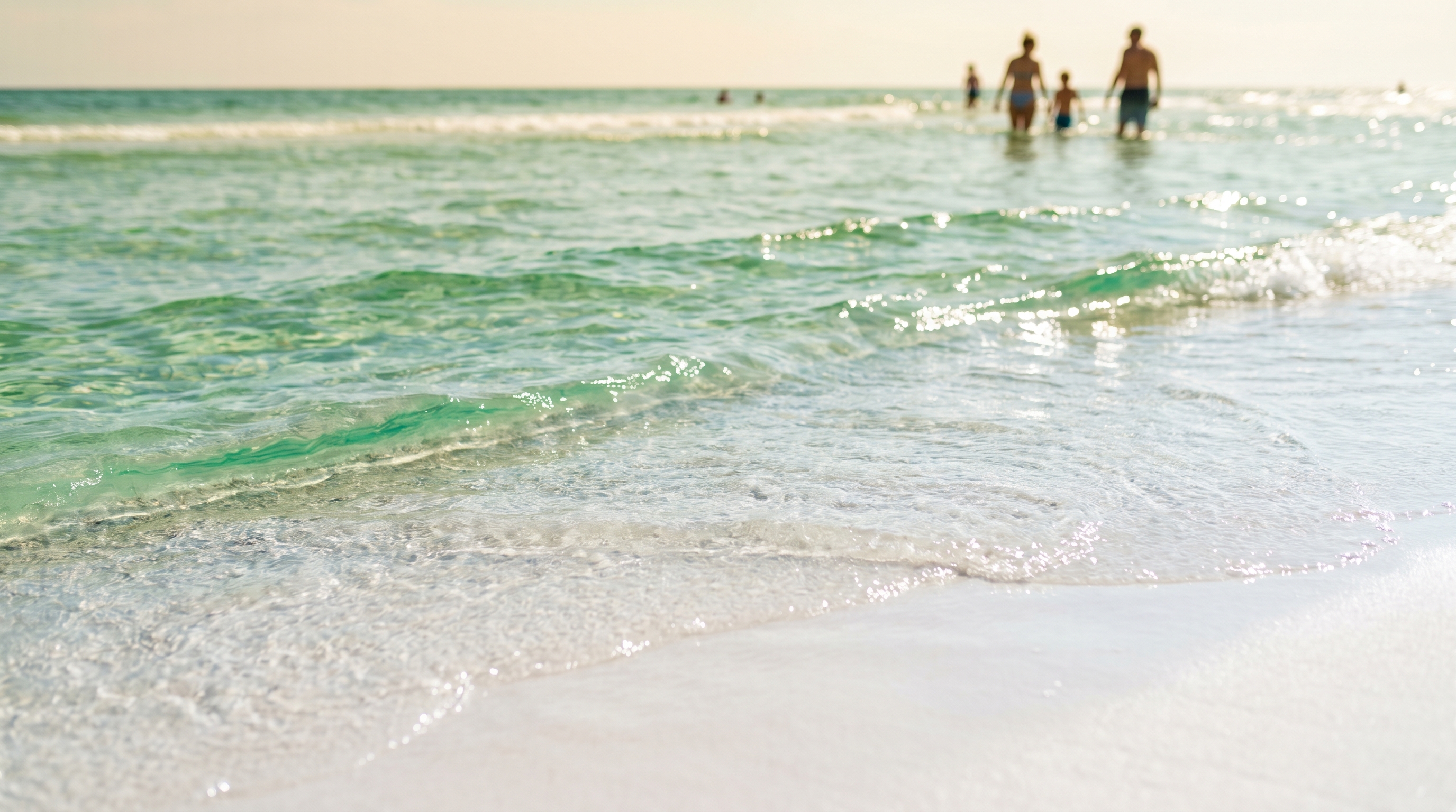 Crystal clear emerald green Gulf of Mexico water at Destin Florida with white sugar sand visible through the shallow surf