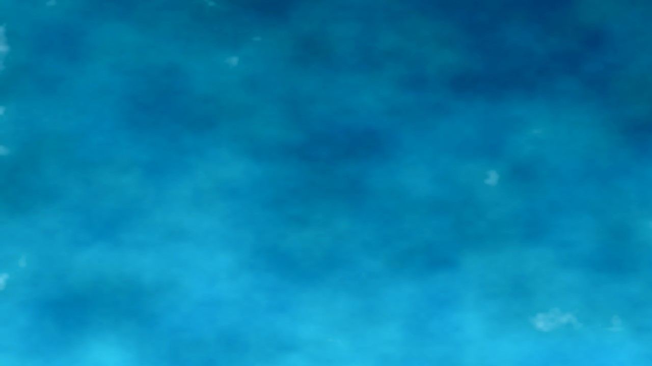 Crystal-clear turquoise water over brilliant white sand on the Florida Panhandle Emerald Coast, shot at the waterline on a clear summer day