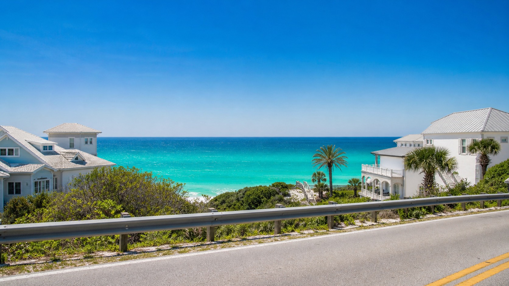 First spectacular view of Destin's emerald green Gulf of Mexico from Florida's Emerald Coast Highway, turquoise water glimmering between beach houses under brilliant midday sunshine