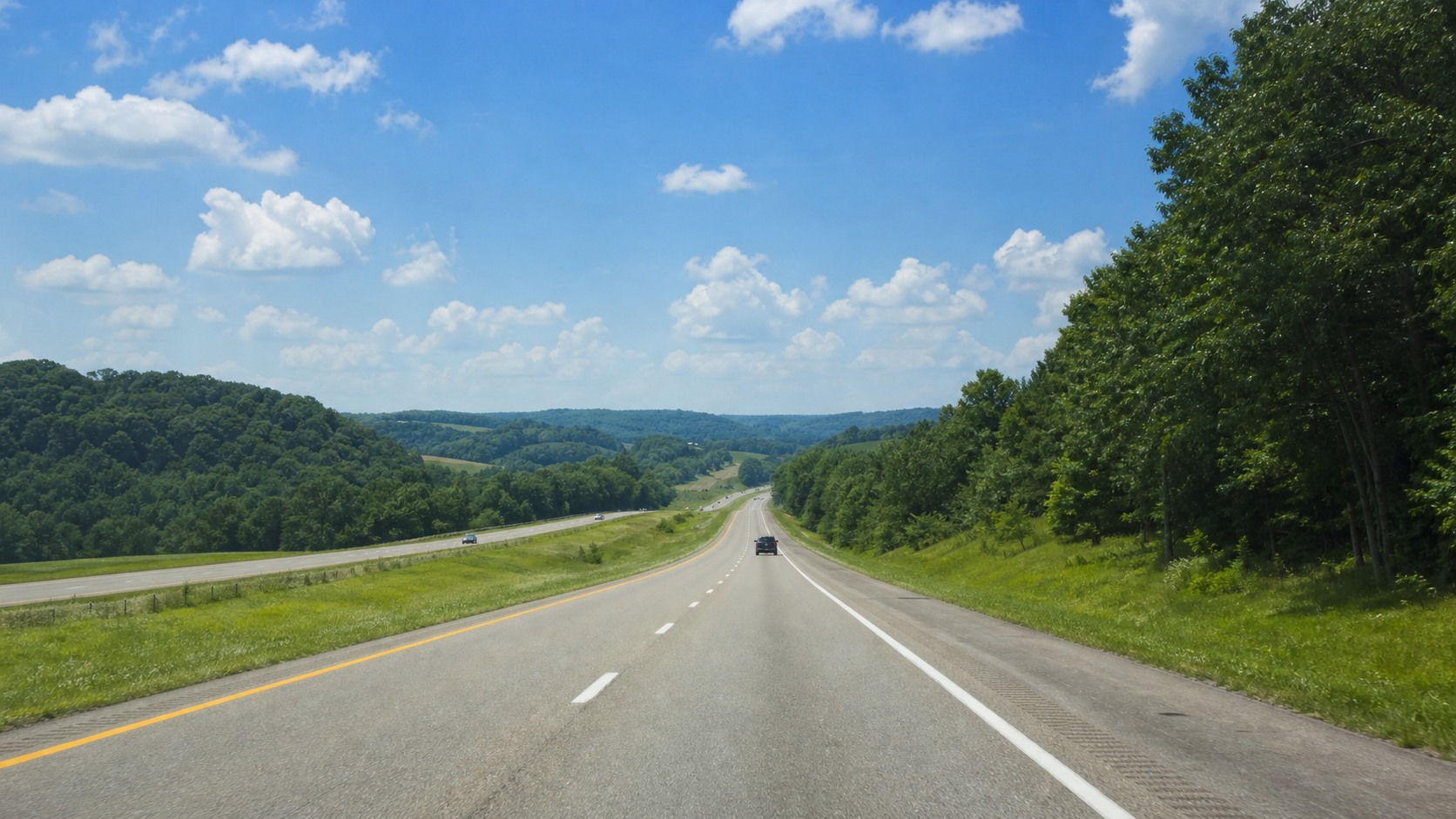 Wide two-lane interstate highway heading south through green summer countryside toward Florida