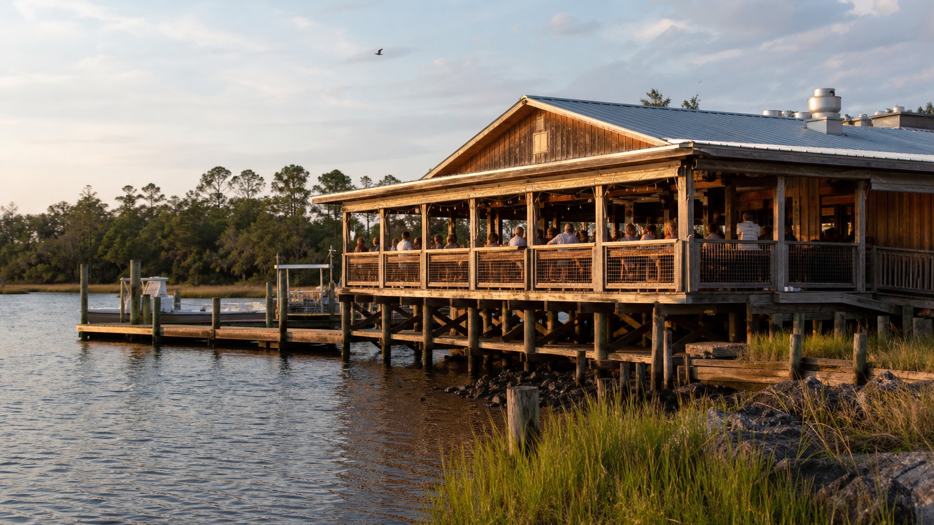Wooden waterfront restaurant with open-air deck seating in the historic coastal town of Apalachicola Florida with the bay visible behind the building