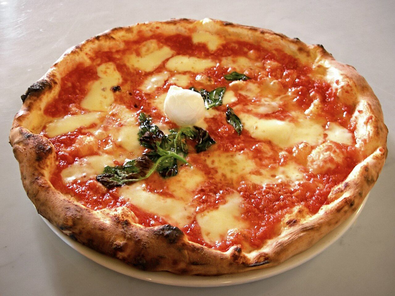 Classic Neapolitan margherita pizza &mdash; the benchmark for pizza quality on the Emerald Coast