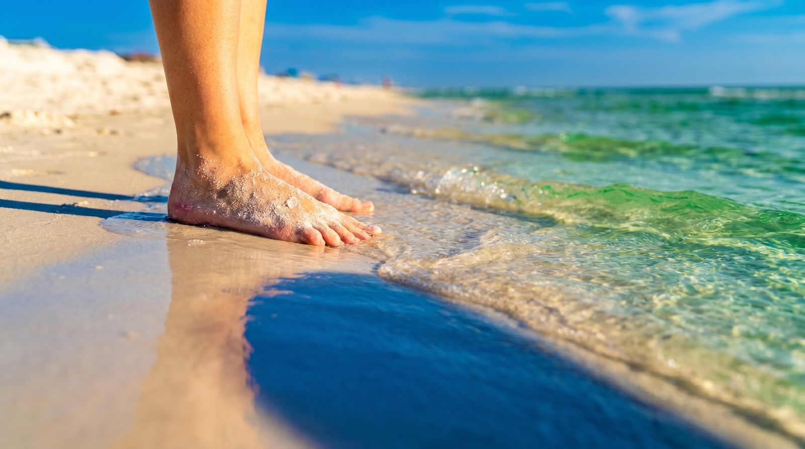Brilliant white quartz sand and emerald-green clear Gulf water at Destin Florida beach on a sunny summer day