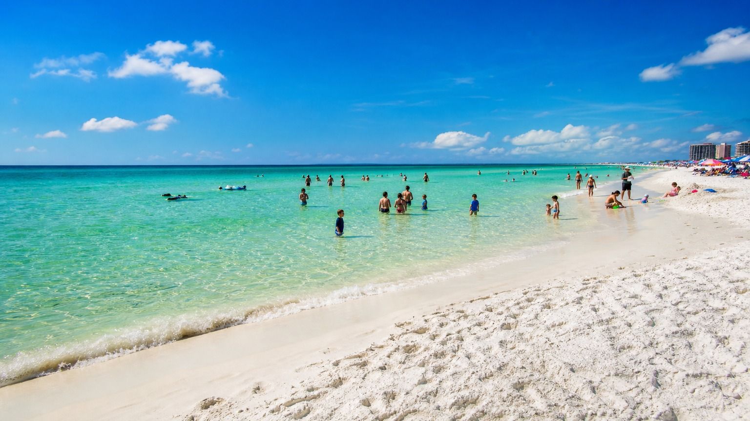 Destin Florida's white quartz sand beach with crystal-clear emerald Gulf water on a sunny summer day