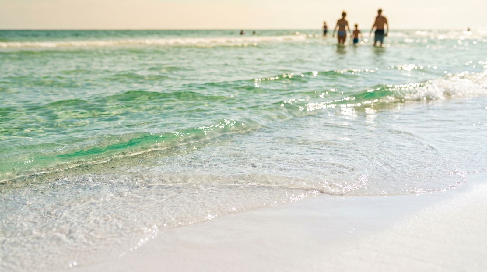 Crystal clear emerald green Gulf of Mexico water at Destin Florida with white sugar sand visible through the shallow surf