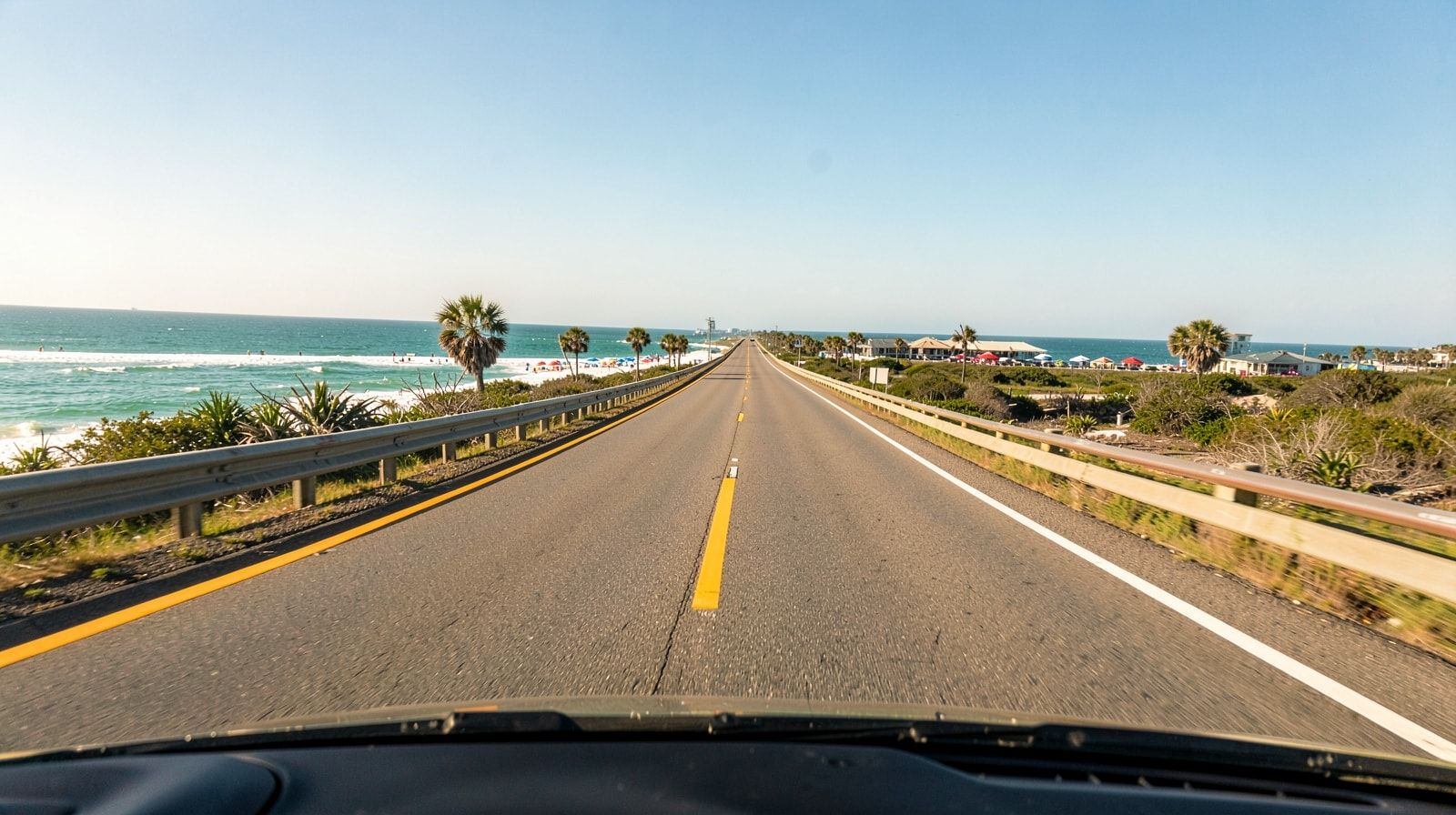 Driver's-eye view of a long straight Texas highway on a sunny day heading east toward the Gulf Coast